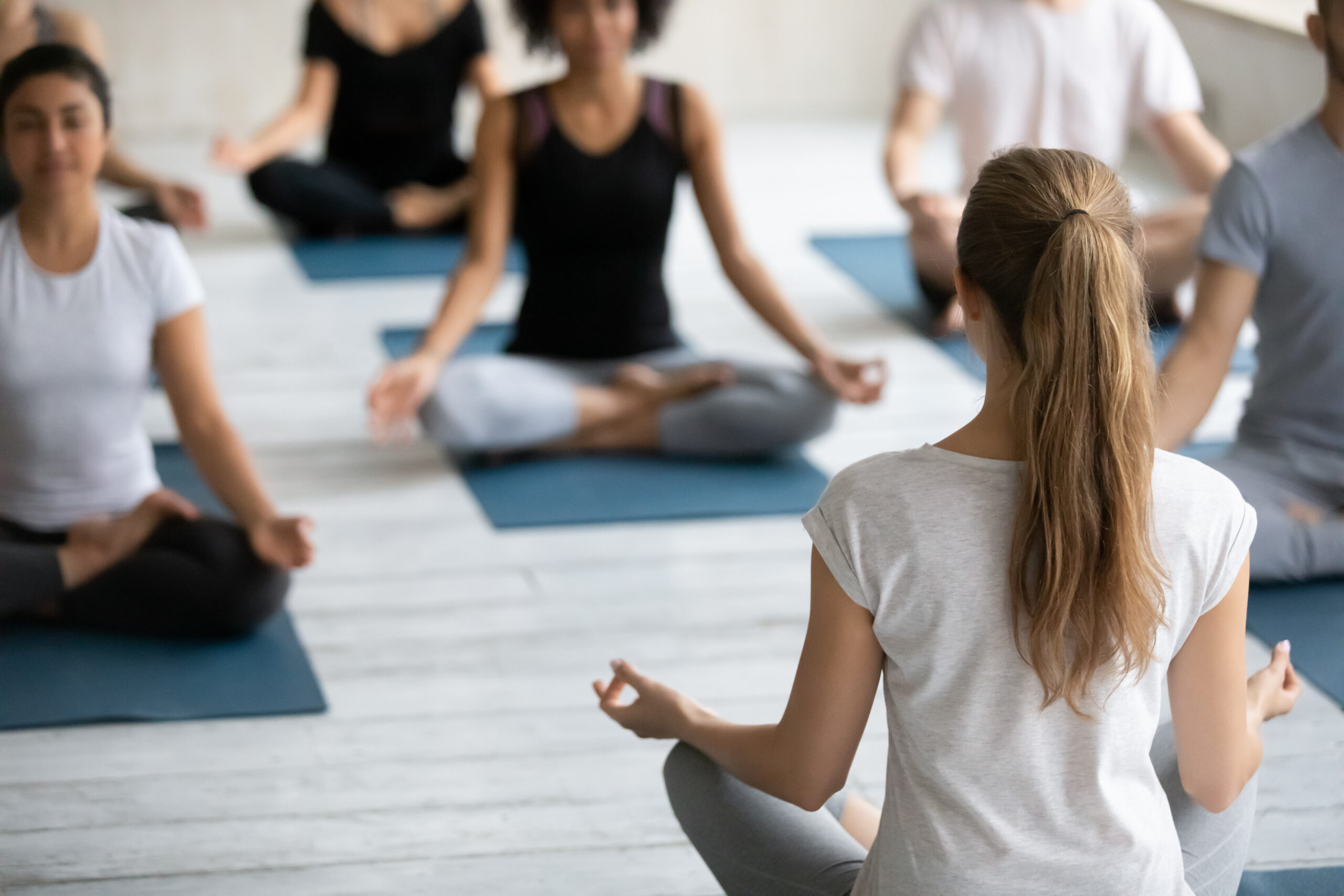 Rear,Back,View,Woman,Yoga,Coach,And,Group,Of,People